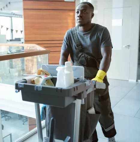 a man walking with a cleaning cart