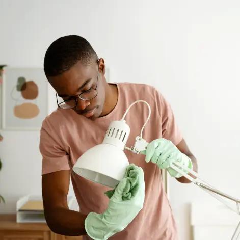 a man cleaning a lamp