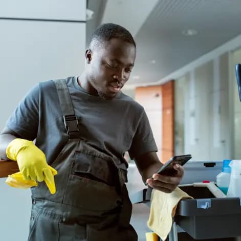 a male cleaner operating a smart phone.